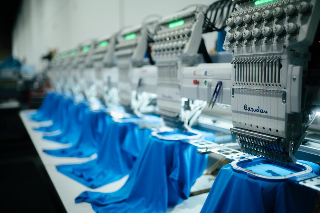Barudan multi-head embroidery machines running a garment order at From The Ashes in Naples, FL