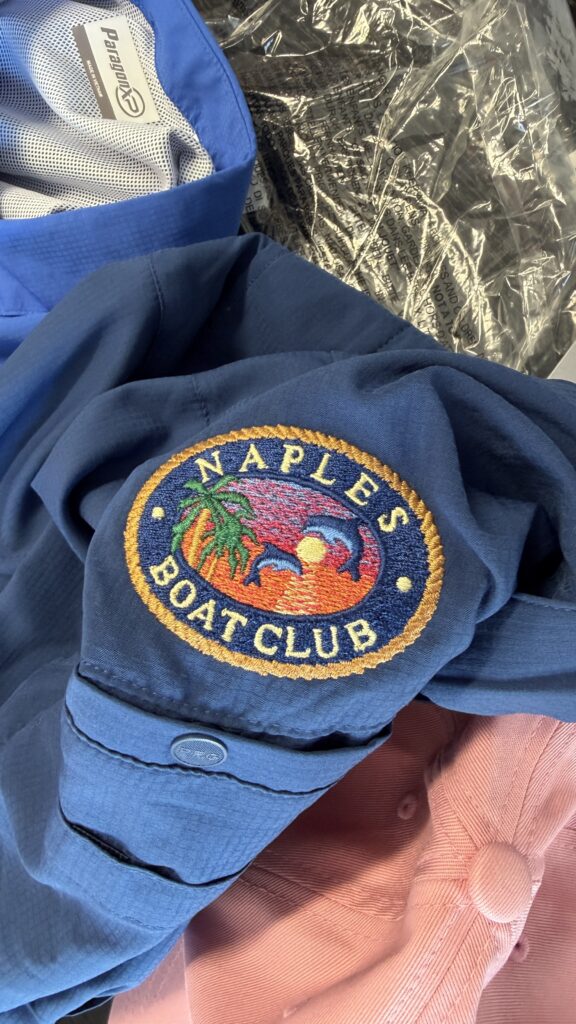 Embroidered Naples Boat Club patch stitched onto a blue jacket